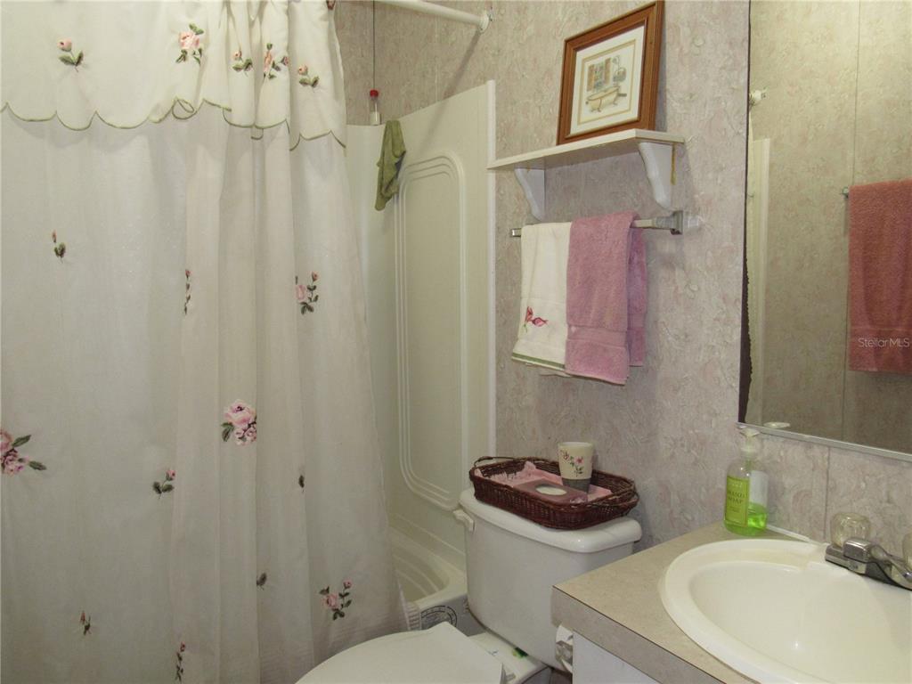 10101 Burnt Store Road, Unit 52 Punta Gorda, FL 33950 - Photo 18 of 37 a bathroom with a sink a toilet a shower and a mirror