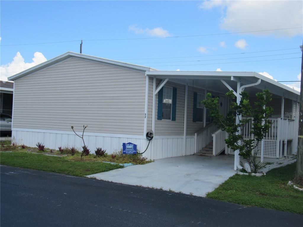 10101 Burnt Store Road, Unit 52 Punta Gorda, FL 33950 - Photo 2 of 37 a view of a house with backyard and a garden