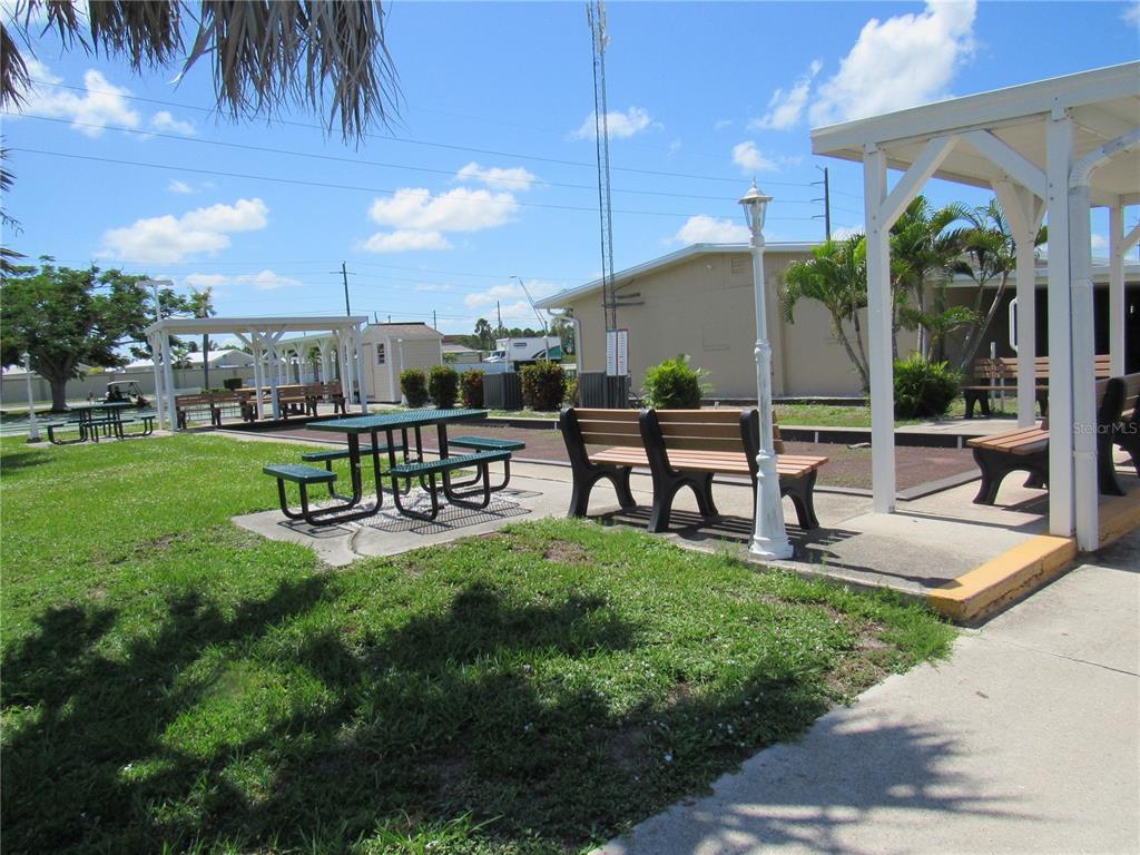 10101 Burnt Store Road, Unit 52 Punta Gorda, FL 33950 - Photo 33 of 37 a swimming pool with outdoor seating and a garden