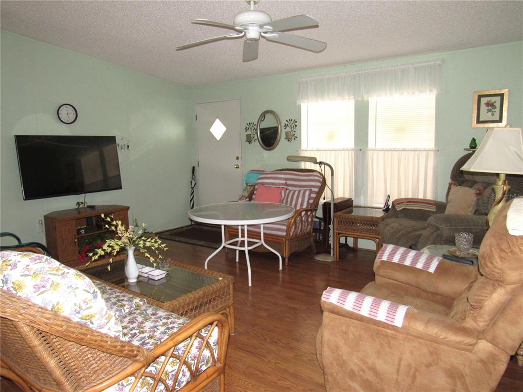 10101 Burnt Store Road, Unit 52 Punta Gorda, FL 33950 - Photo 6 of 37 a living room with furniture a flat screen tv and a chandelier