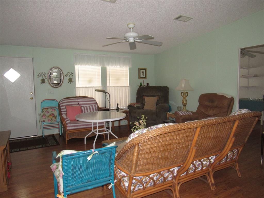 10101 Burnt Store Road, Unit 52 Punta Gorda, FL 33950 - Photo 7 of 37 a living room with furniture a clock and a window