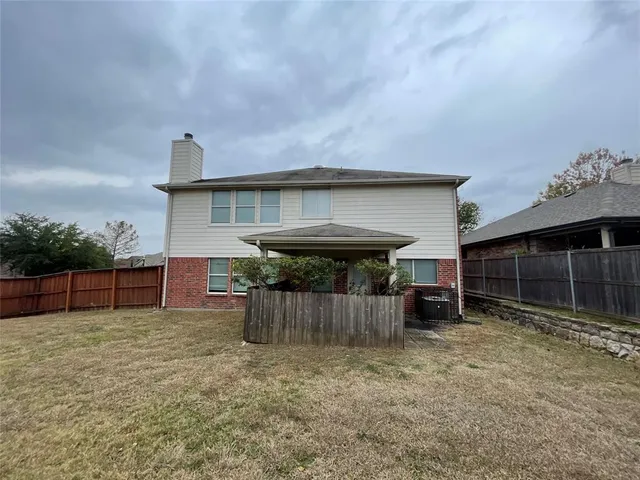 a view of a house with a yard and wooden fence