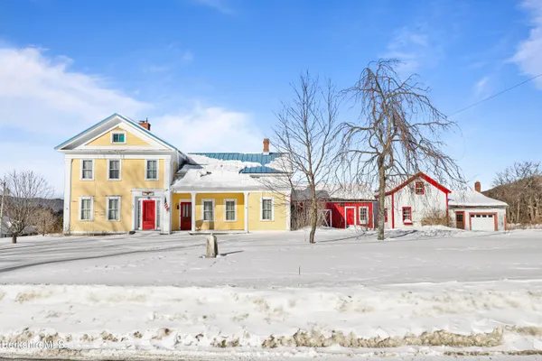 a view of small white house with large windows