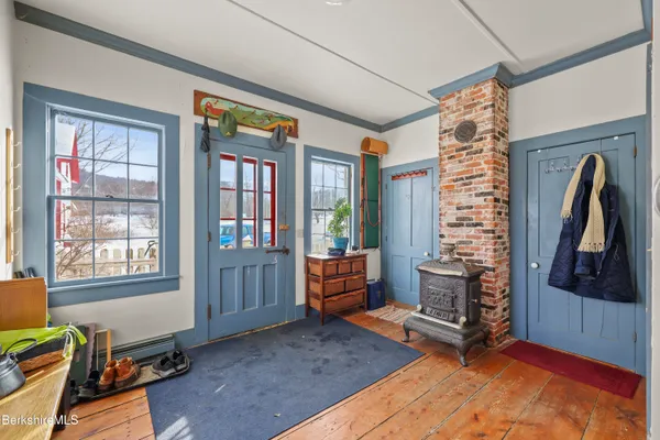 a view of a hallway to an empty room and wooden floor