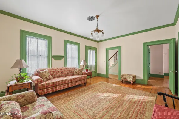 a spacious bedroom with a bed a chandelier and a dresser