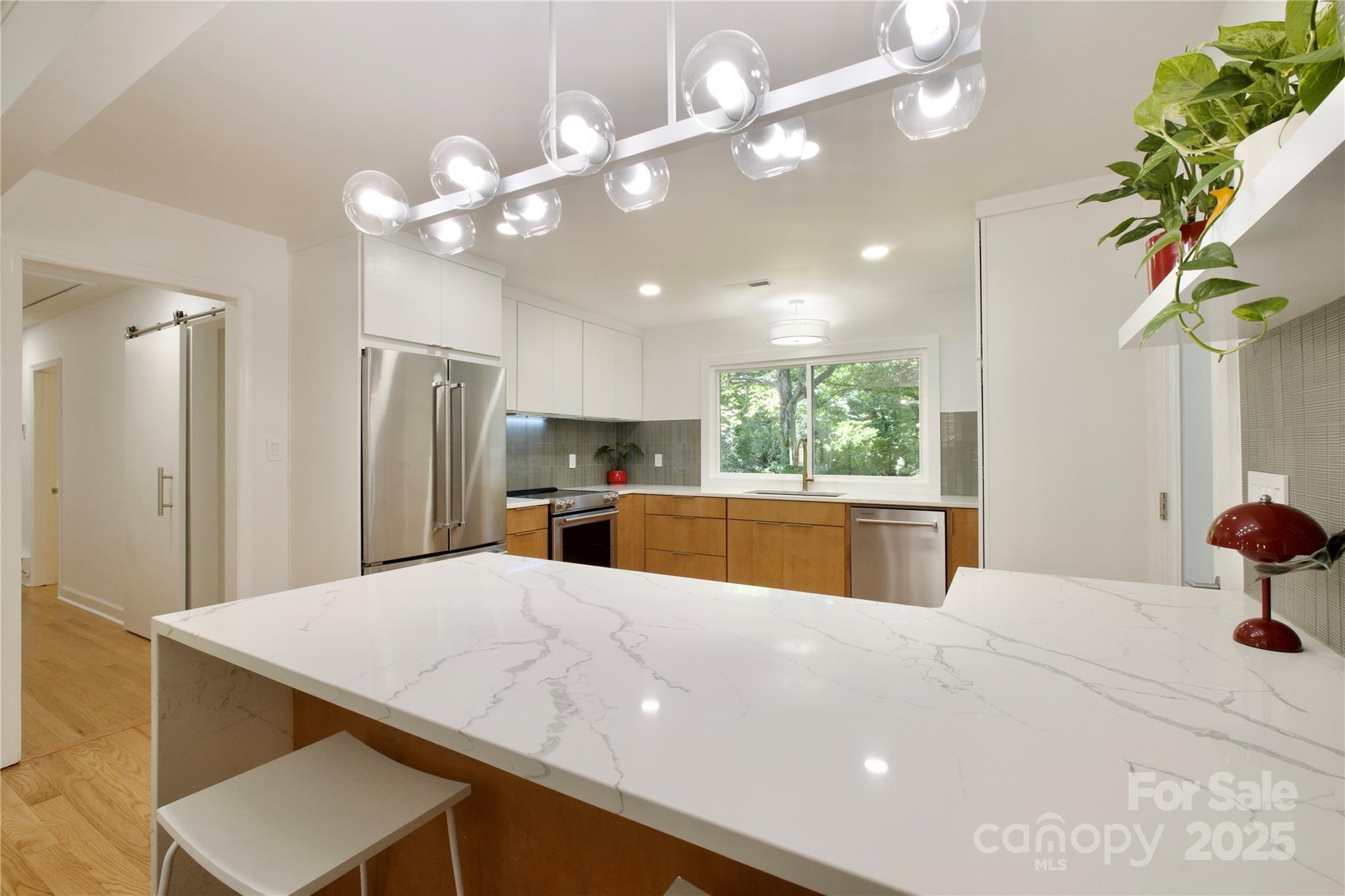 3549 Woodleaf Road Charlotte, NC 28205 - Photo 12 of 43 a large kitchen with stainless steel appliances a large kitchen island attached withe living room