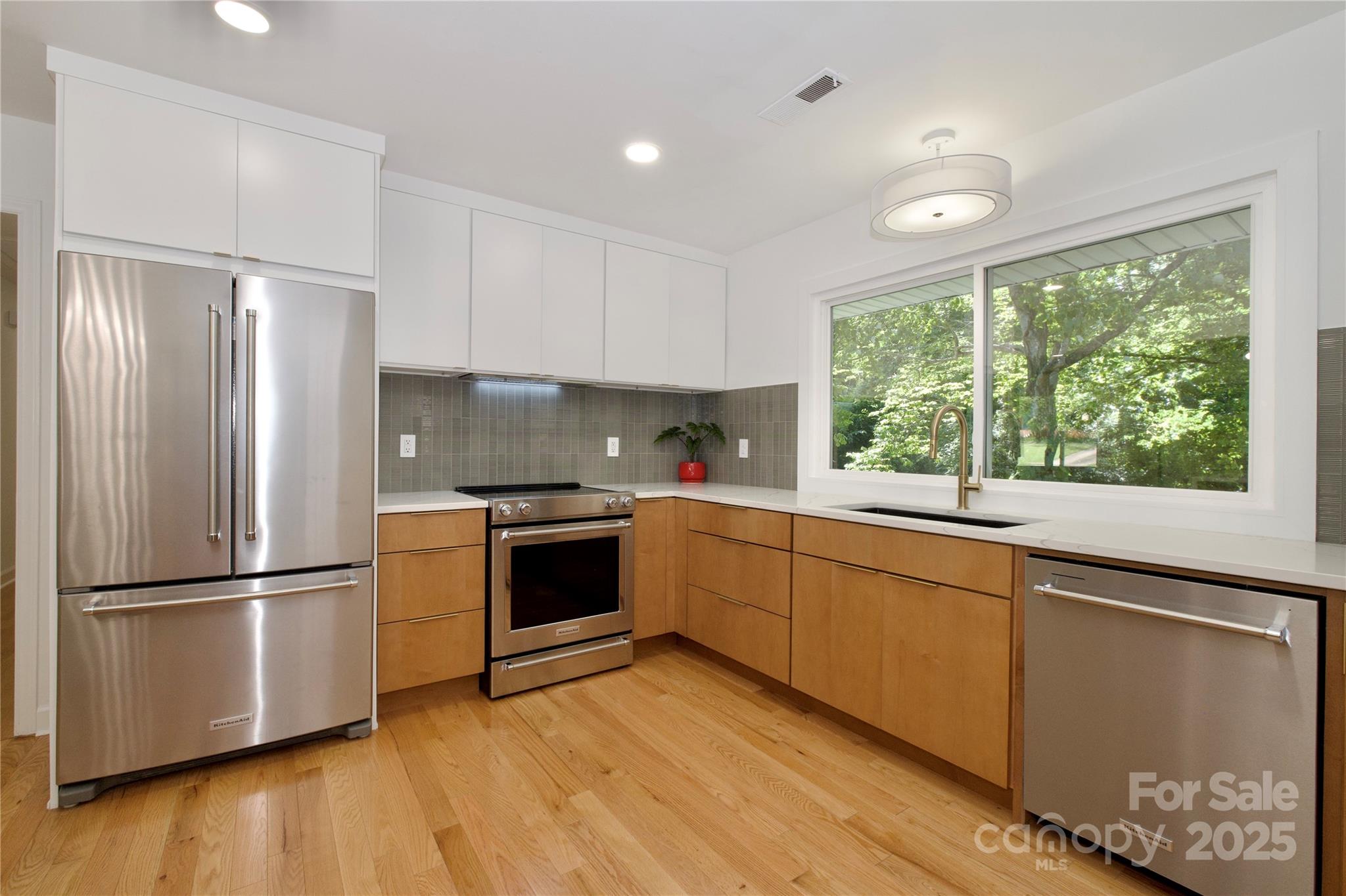 3549 Woodleaf Road Charlotte, NC 28205 - Photo 15 of 43 a kitchen with wooden floors and stainless steel appliances