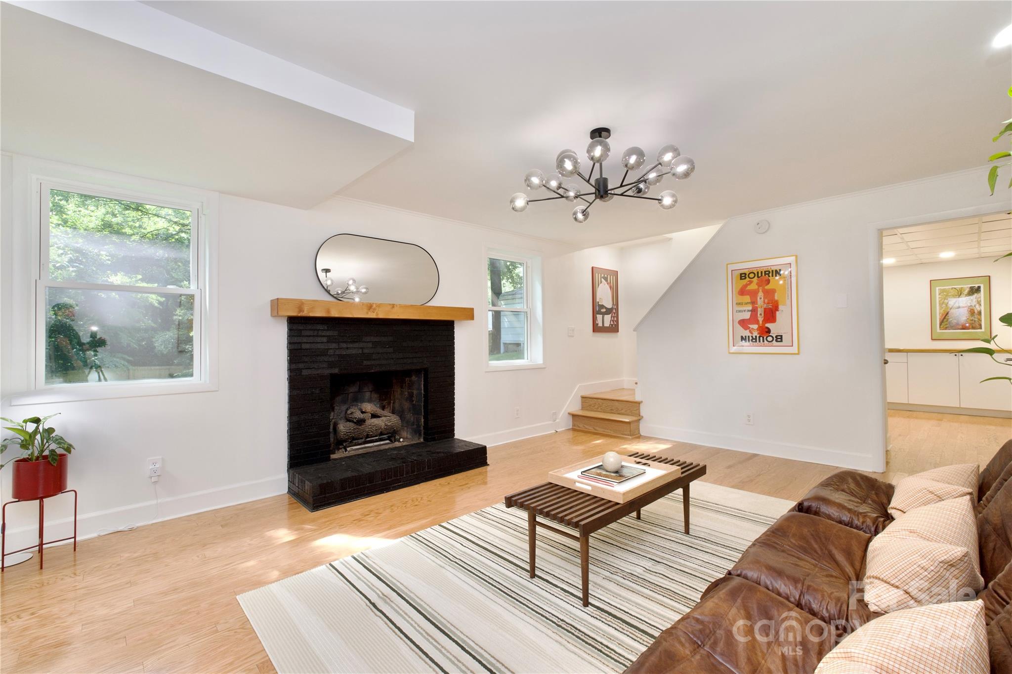 3549 Woodleaf Road Charlotte, NC 28205 - Photo 30 of 43 a living room with furniture a chandelier and a fireplace