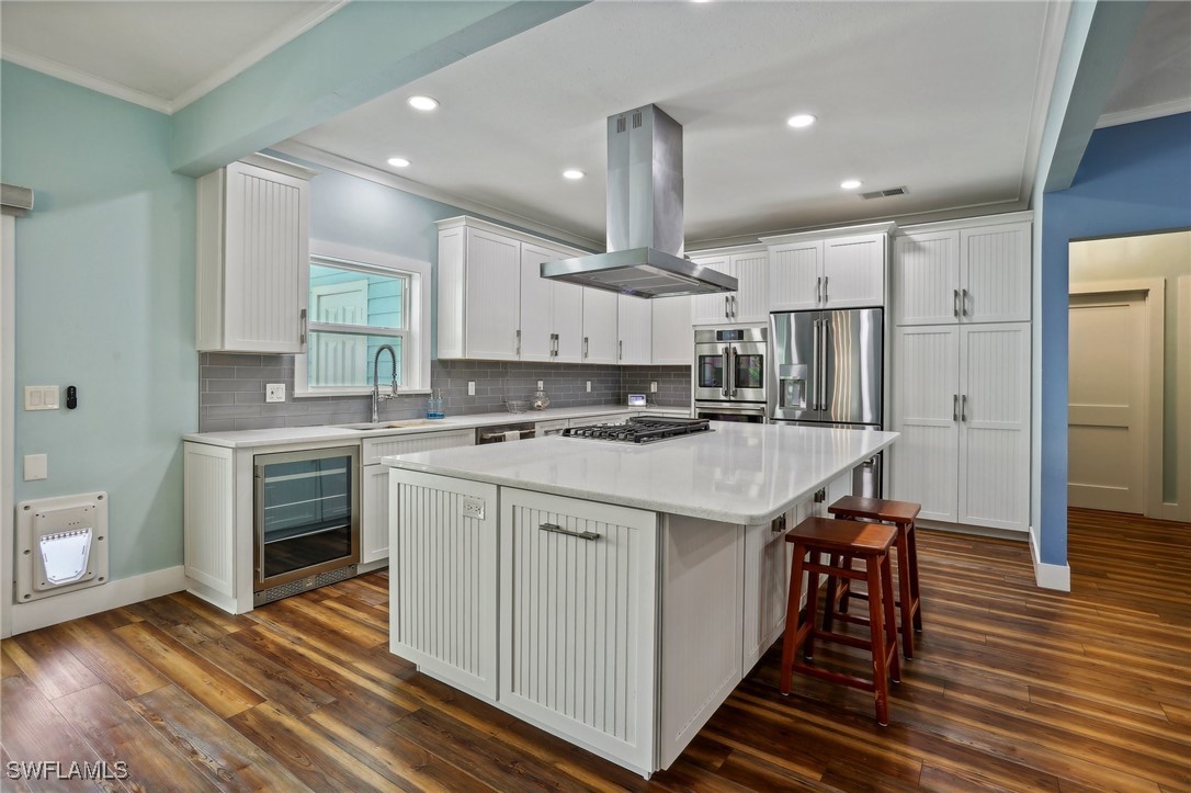 8335 Main Street Bokeelia, FL 33922 - Photo 22 of 47 a kitchen with stainless steel appliances kitchen island granite countertop a stove a sink and a refrigerator