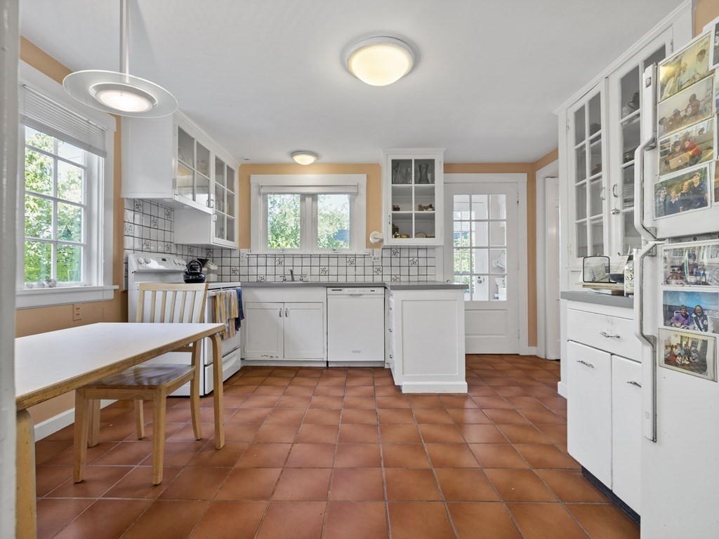 14 Birch Road Wellesley, MA 02482 - Photo 8 of 18 a kitchen with stainless steel appliances granite countertop a stove top oven a sink a dining table and chairs
