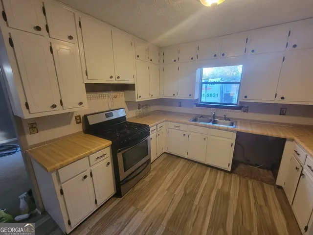 a kitchen with a sink stove and cabinets