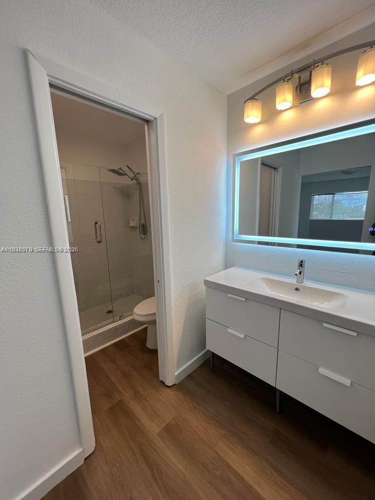 9727 Hammocks Boulevard, Unit 202D Miami, FL 33196 - Photo 11 of 16 a bathroom with a sink a toilet and a shower