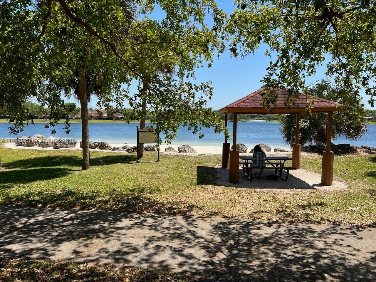 9727 Hammocks Boulevard, Unit 202D Miami, FL 33196 - Photo 14 of 16 a view of a backyard with table and chairs