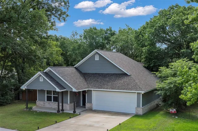 a aerial view of a house with a yard potted plants and large tree