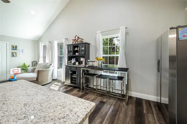 a work room with furniture a rug and a window