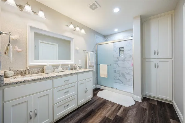 a bathroom with a granite countertop sink mirror and shower