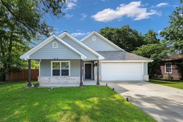 a front view of a house with a garden and yard