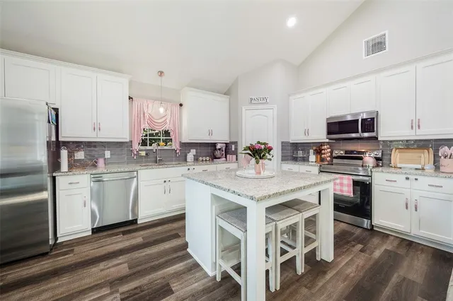 a kitchen with a sink stove cabinets and refrigerator