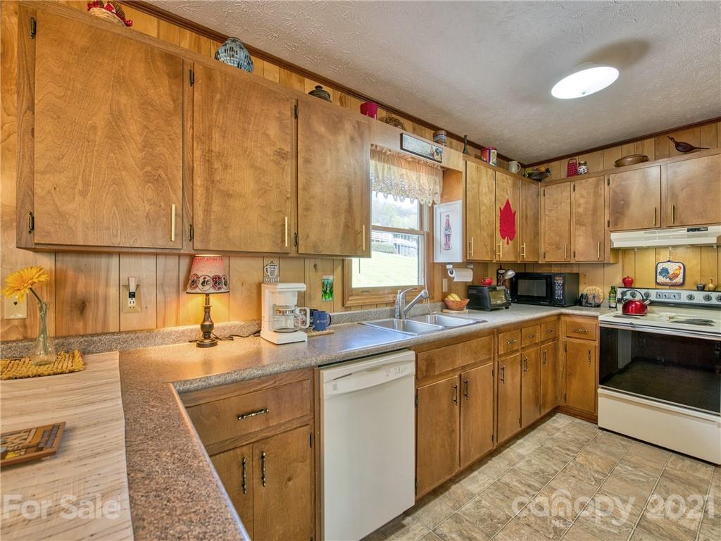 444 Stoney Ridge Loop Maggie Valley, NC 28751 - Photo 11 of 25 a kitchen with kitchen island granite countertop a sink stove and cabinets