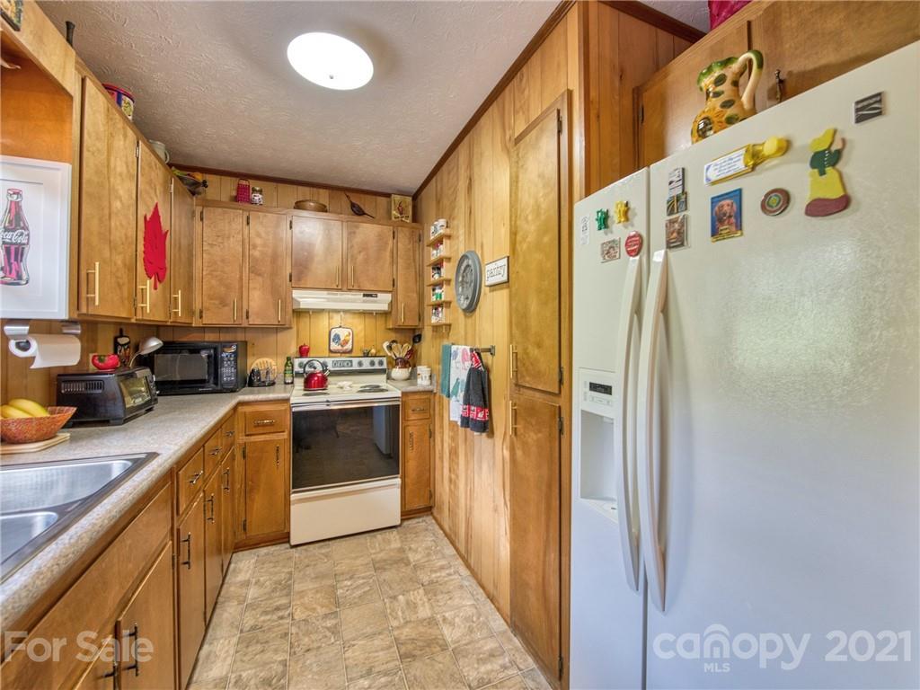 444 Stoney Ridge Loop Maggie Valley, NC 28751 - Photo 12 of 25 a kitchen with stainless steel appliances granite countertop a refrigerator and a sink