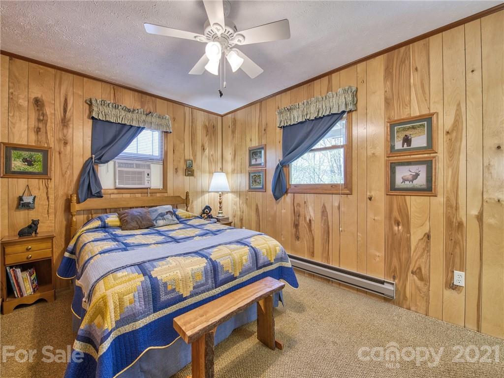 444 Stoney Ridge Loop Maggie Valley, NC 28751 - Photo 14 of 25 a bedroom with a bed and a chandelier