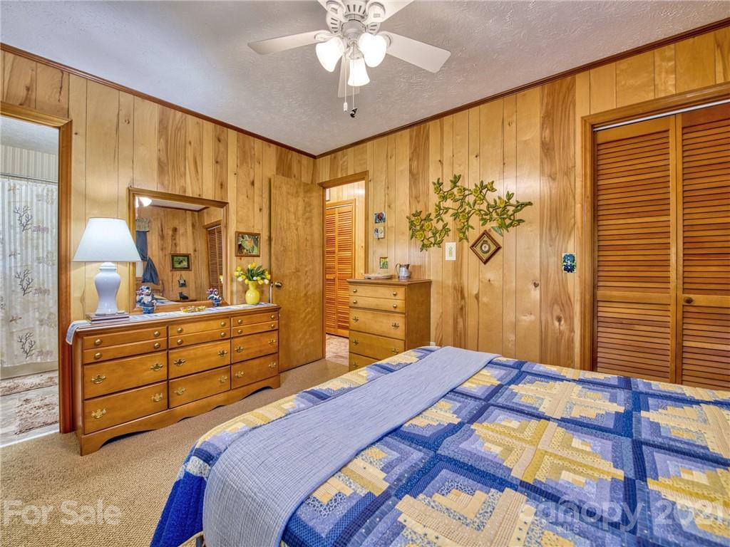 444 Stoney Ridge Loop Maggie Valley, NC 28751 - Photo 15 of 25 a bedroom with a bed and a chandelier