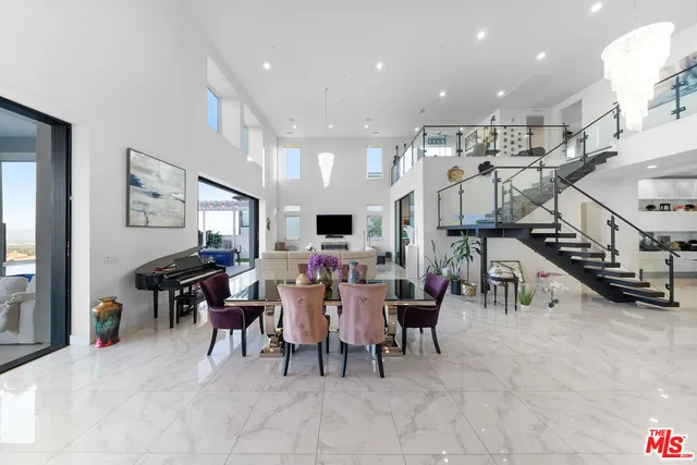 a living room with lots of furniture and a ceiling fan