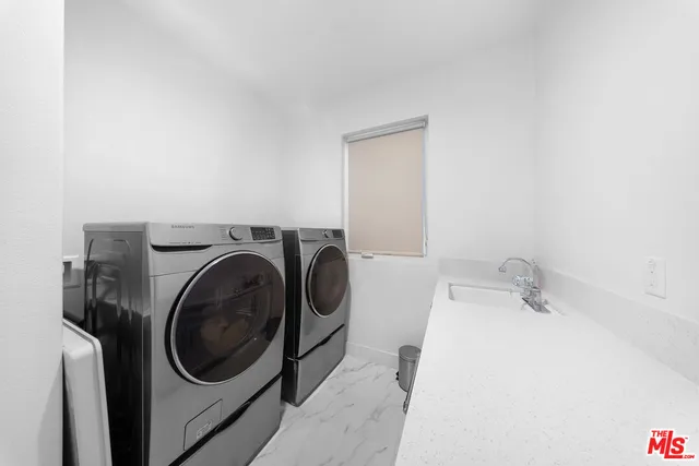 a large white kitchen with a large kitchen island white cabinets and stainless steel appliances