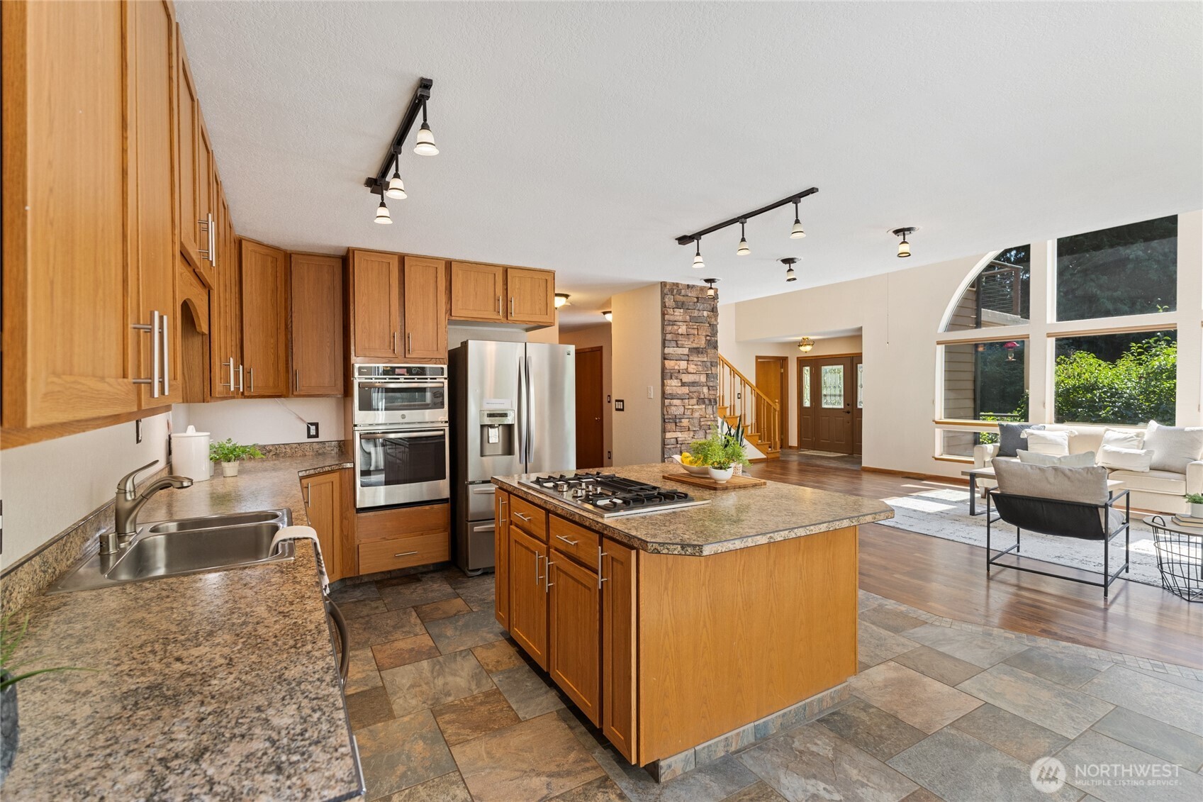 20 Bluebird Lane Port Ludlow, WA 98365 - Photo 13 of 40 a kitchen with stainless steel appliances granite countertop a stove top oven a sink dishwasher a dining table and chairs with wooden floor