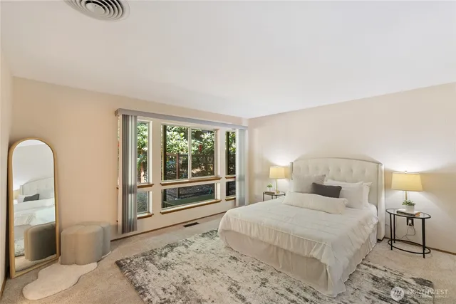 a bedroom with a bed and a large window