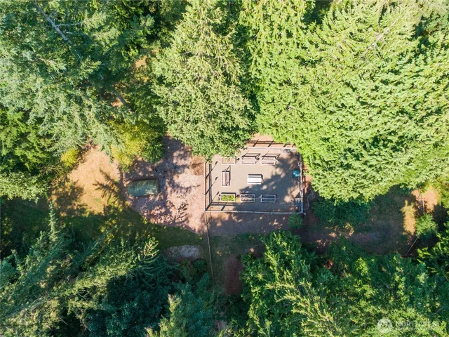 an aerial view of residential houses with outdoor space and trees