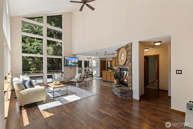 a living room with furniture large window and wooden floor