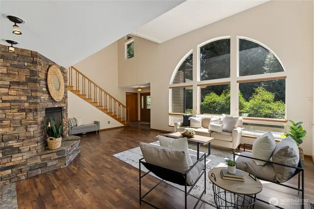 a living room with couches and a dining table with wooden floor