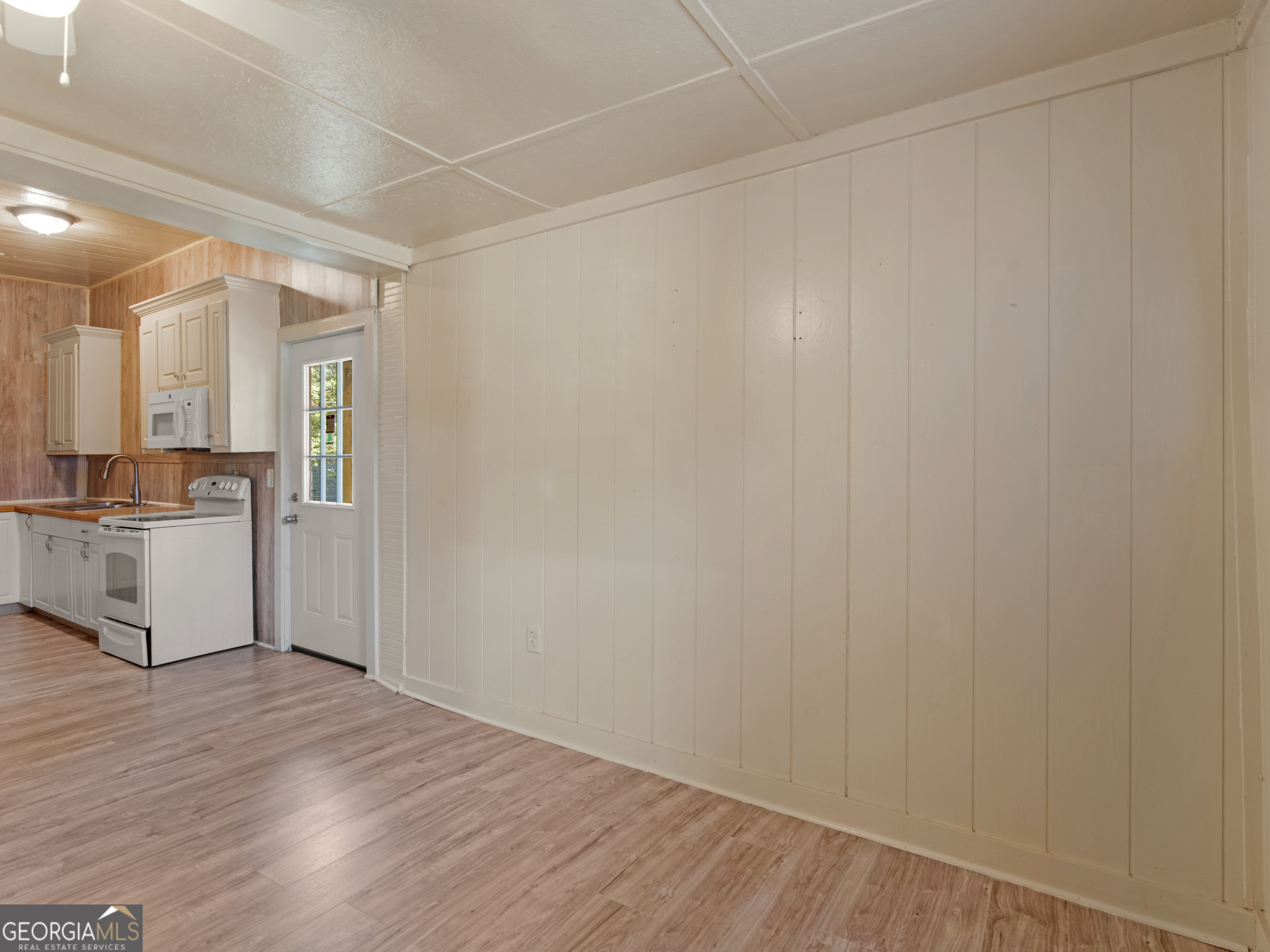 245 Atlanta Street Barnesville, GA 30204 - Photo 17 of 36 a view of a kitchen with white cabinets and wooden floor