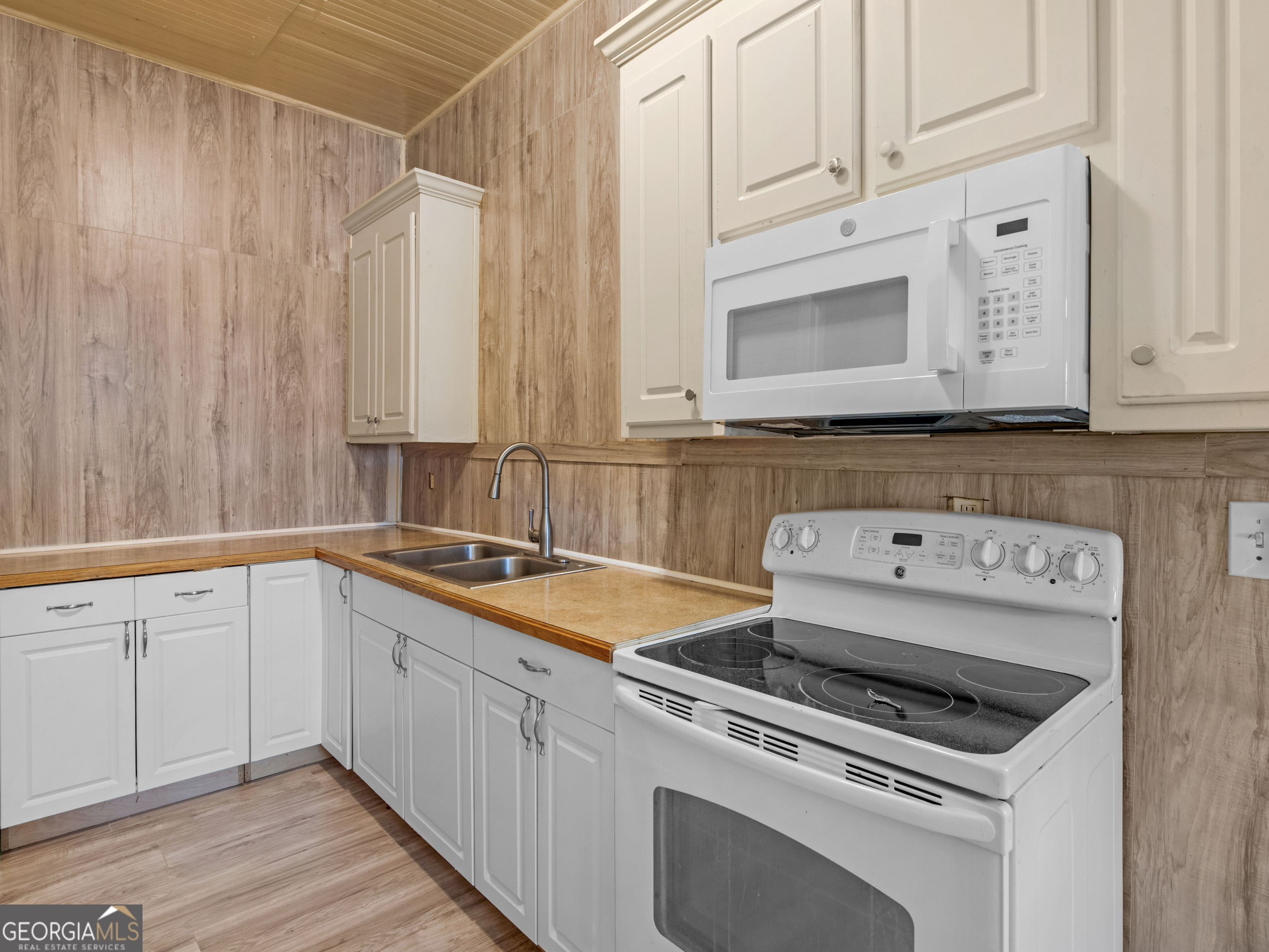 245 Atlanta Street Barnesville, GA 30204 - Photo 24 of 36 a kitchen with granite countertop a sink stove and cabinets