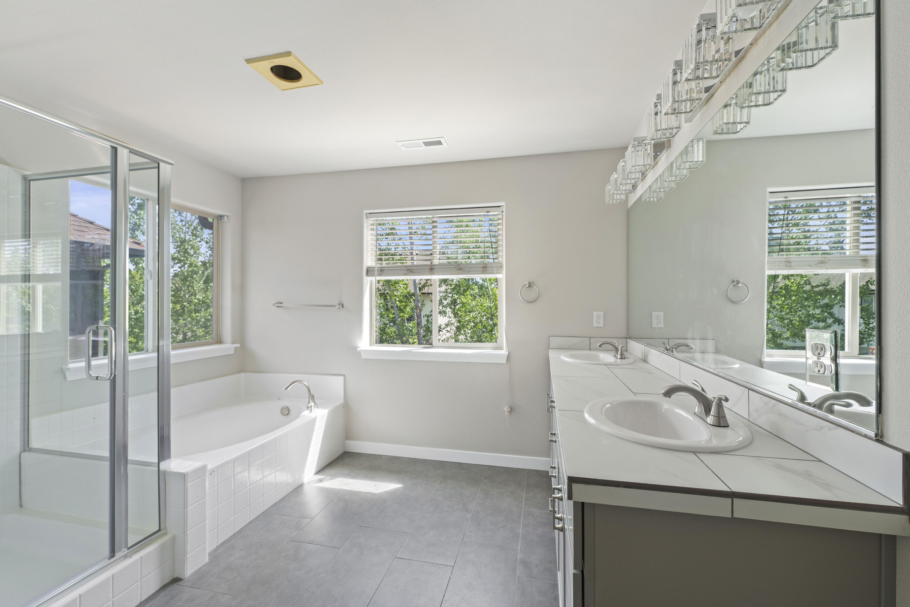 21189 Ritz Place Bend, OR 97702 - Photo 26 of 37 a bathroom with a granite countertop sink a large mirror and a bathtub