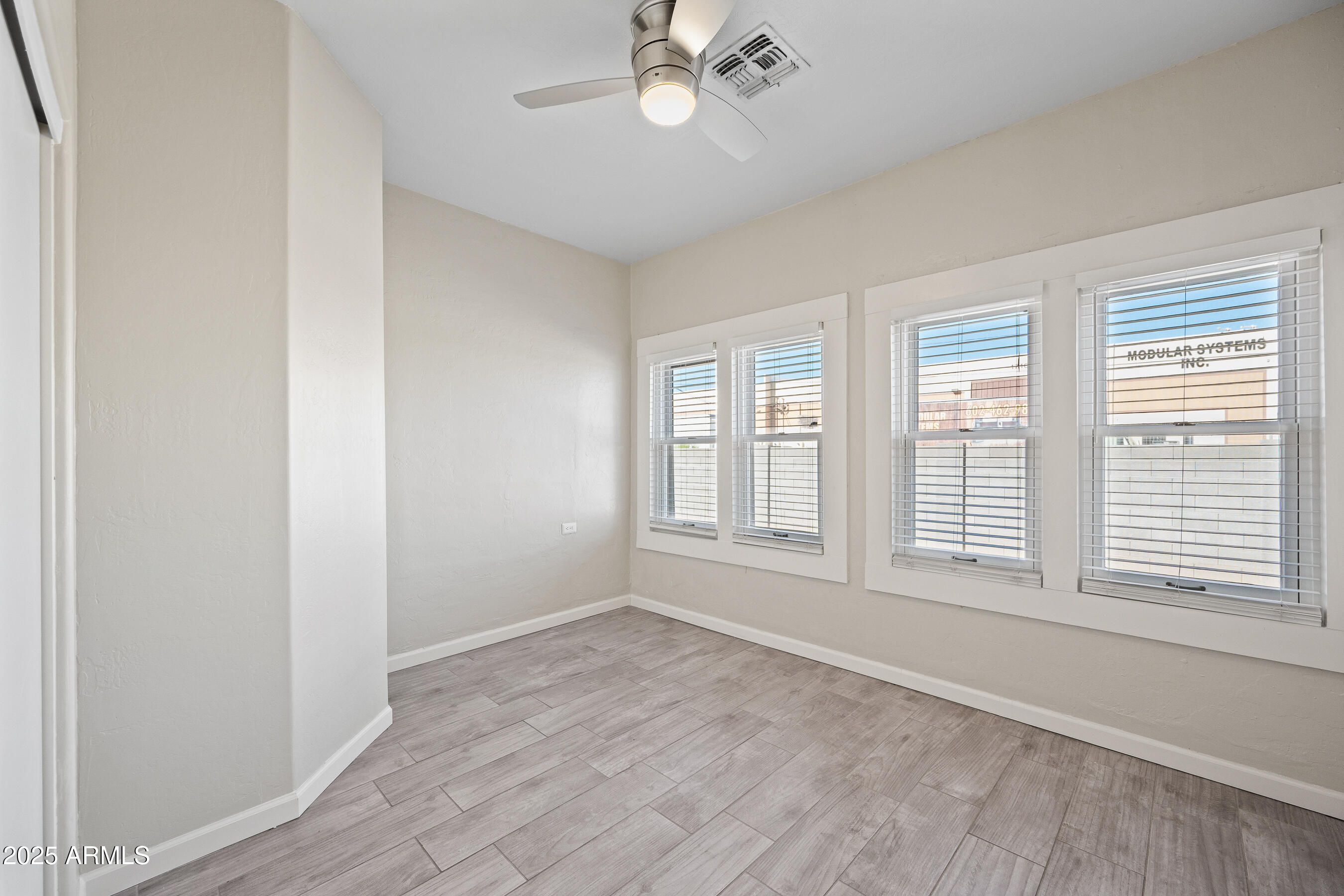 438 North 17th Avenue, Unit A Phoenix, AZ 85007 - Photo 12 of 20 an empty room with wooden floor fan and windows