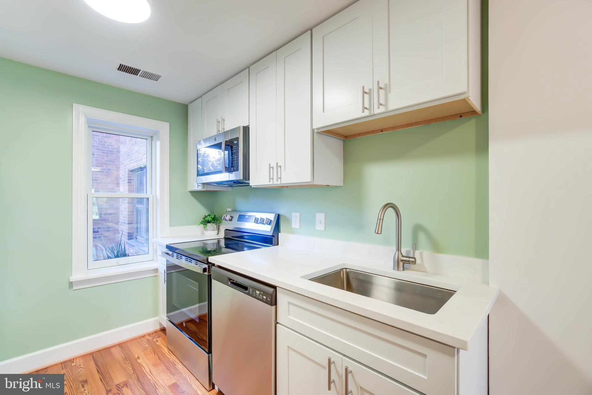 1724 17th Street Northwest, Unit 71 Washington, DC 20009 - Photo 13 of 23 a kitchen with stainless steel appliances a sink a stove and cabinets