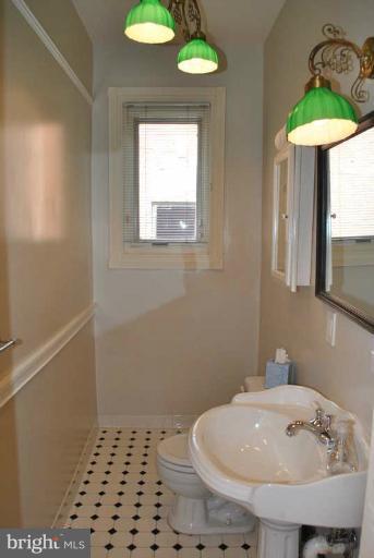 a bathroom with a sink a light fixture and a toilet