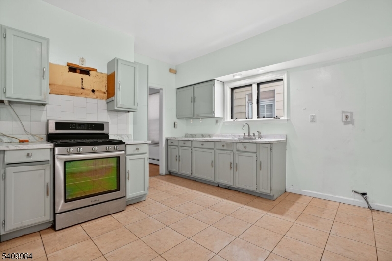 1110 Hampton Place Elizabeth, NJ 07201 - Photo 2 of 23 a kitchen with a stove sink and cabinets