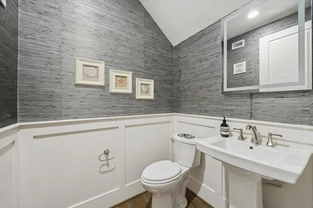 a bathroom with a toilet sink and mirror
