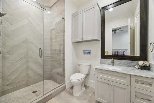 a bathroom with a granite countertop sink a toilet and a mirror