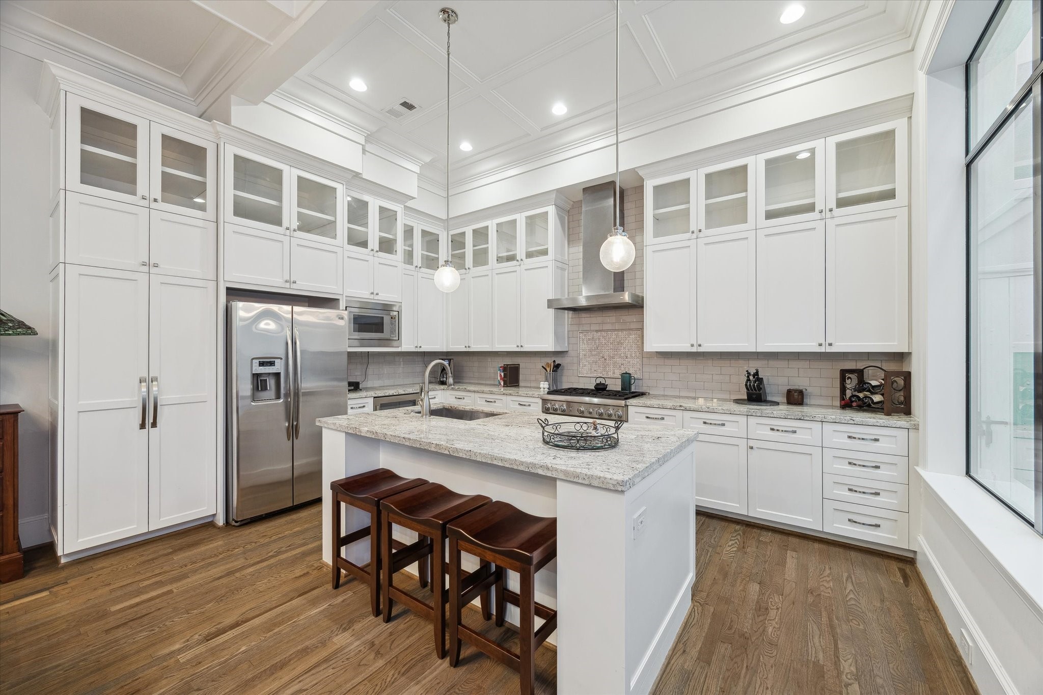 1547 Nevada Street Houston, TX 77006 - Photo 9 of 24 a kitchen with stainless steel appliances a stove a sink dishwasher a refrigerator white cabinets and wooden floor