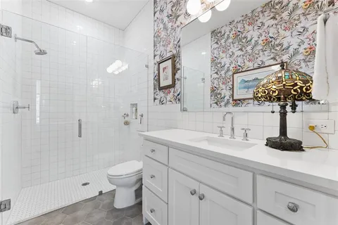 a bathroom with a sink a toilet and a mirror