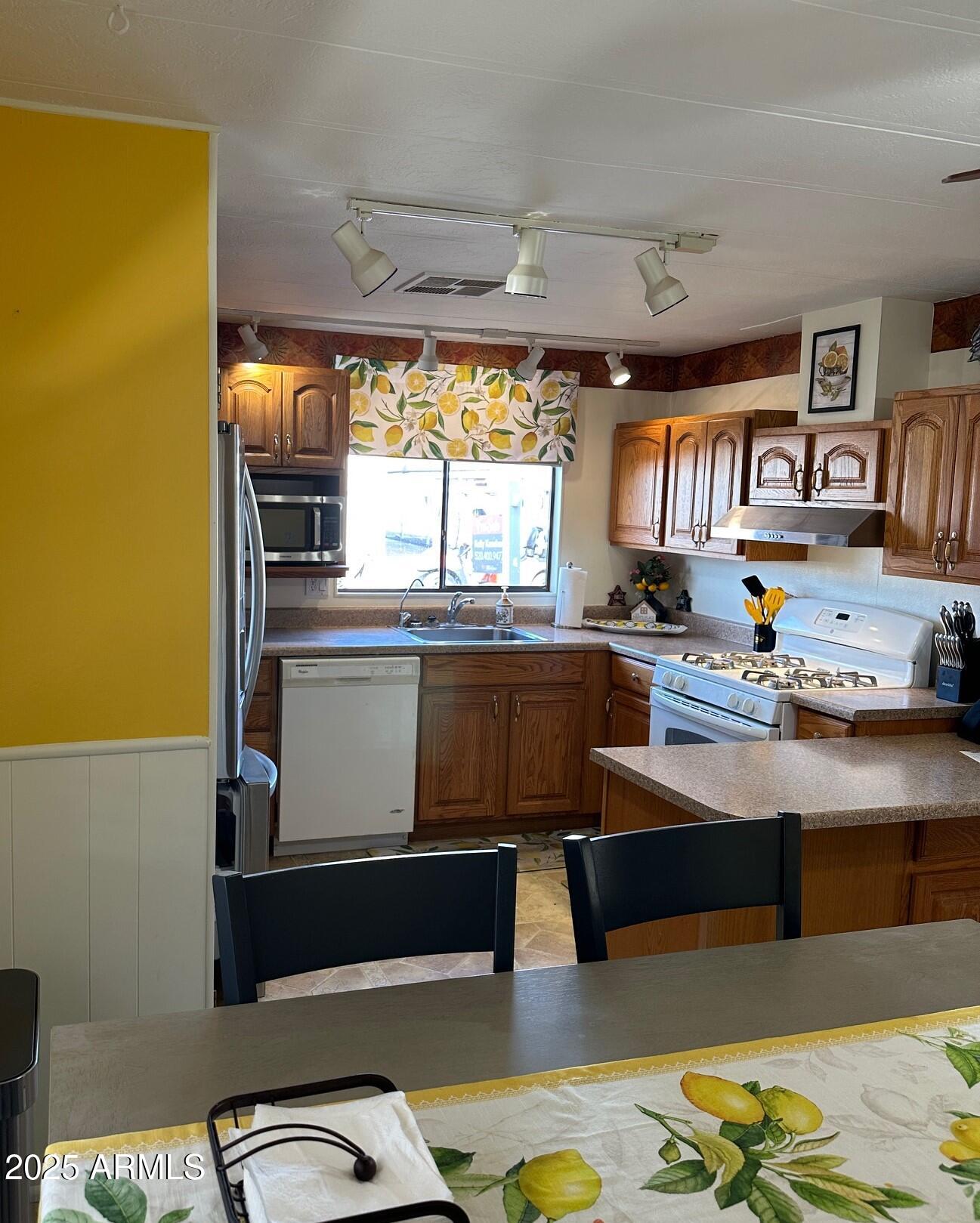 2100 North Trekell Road, Unit 222 Casa Grande, AZ 85122 - Photo 9 of 26 a kitchen with stainless steel appliances granite countertop a sink stove and wooden cabinets