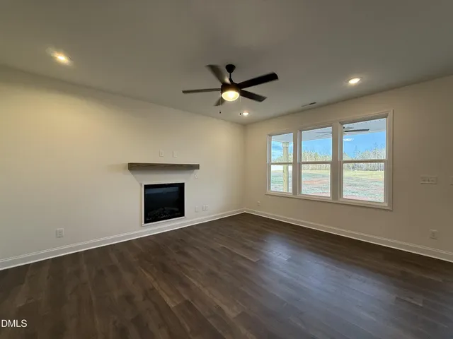an empty room with windows and a fireplace