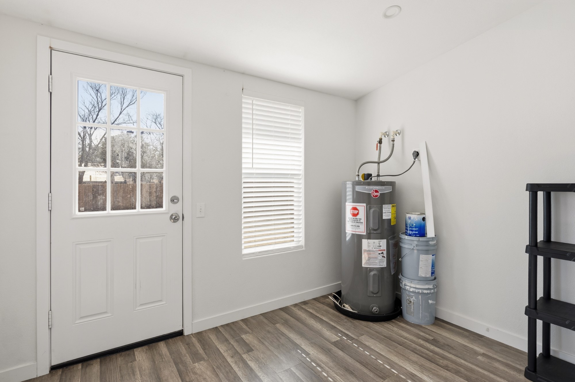 108 Irene Street Elgin, TX 78621 - Photo 20 of 29 Doorway to outside featuring wood finished floors and water heater
