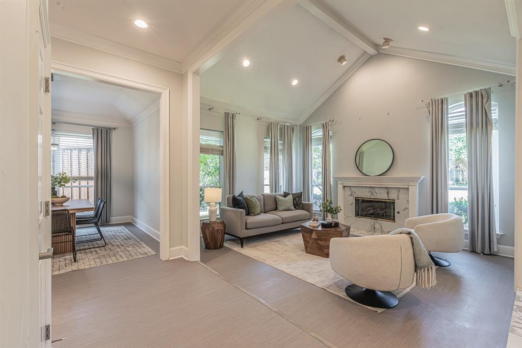300 Sundance Circle Irving, TX 75063 - Photo 5 of 39 Living area featuring a vaulted ceiling with recessed lighting, a fireplace with a stone surround and white mantel, and multiple tall windows