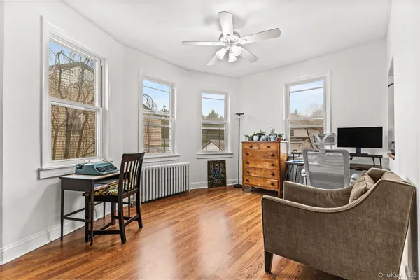 a living room with furniture a dining table and a flat screen tv with wooden floor