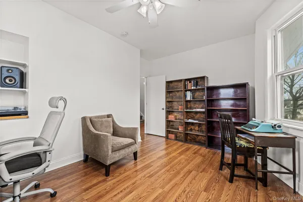 a living room with furniture a piano and a bookshelf